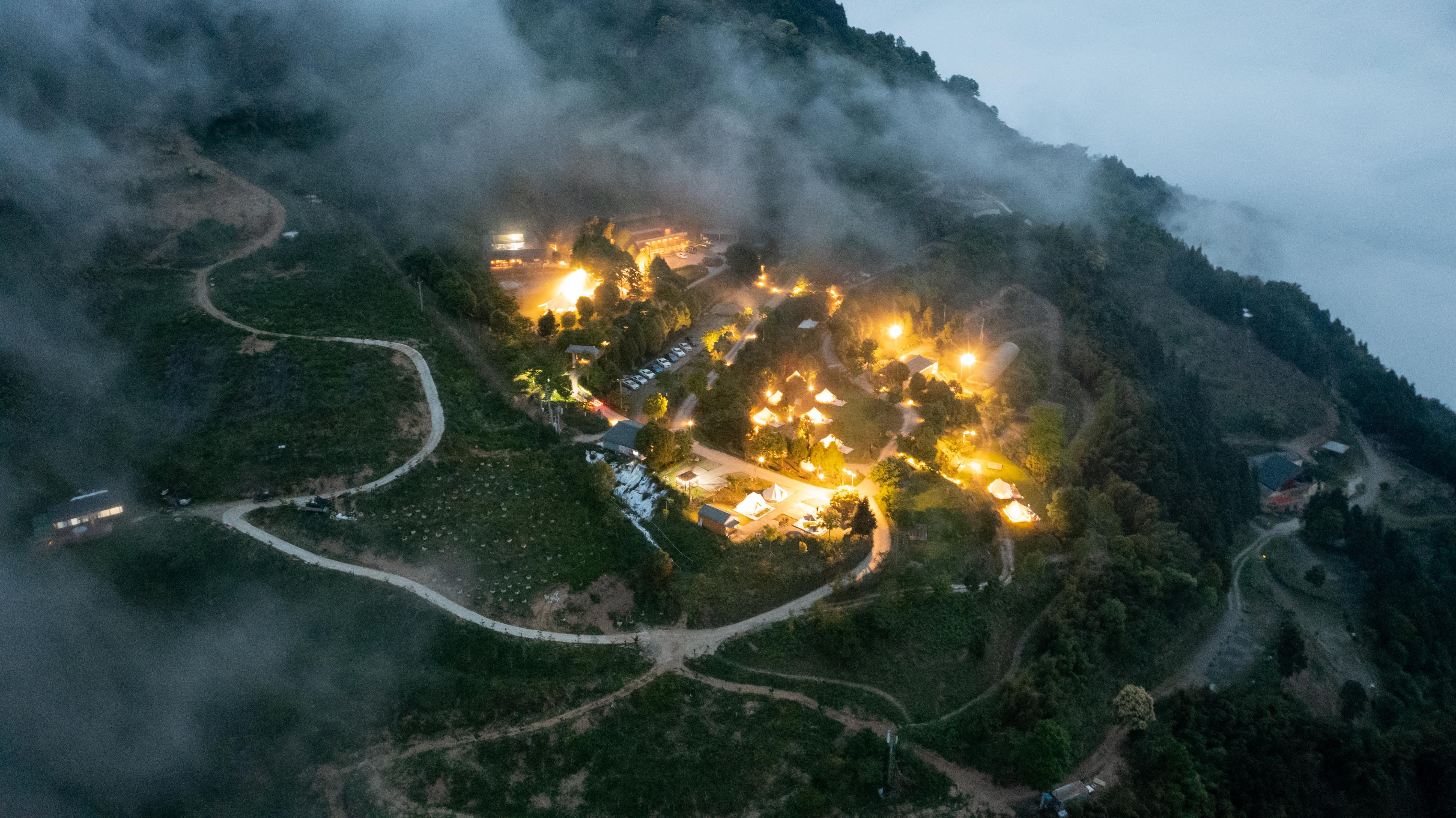 雲霧中的新竹山林場地夜間點燈空拍